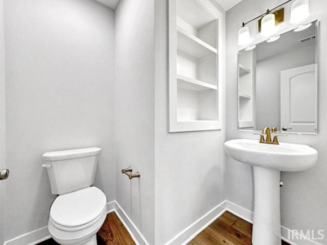 bathroom with sink, hardwood / wood-style floors, and toilet