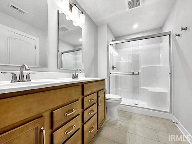 bathroom featuring tile patterned flooring, an enclosed shower, vanity, and toilet