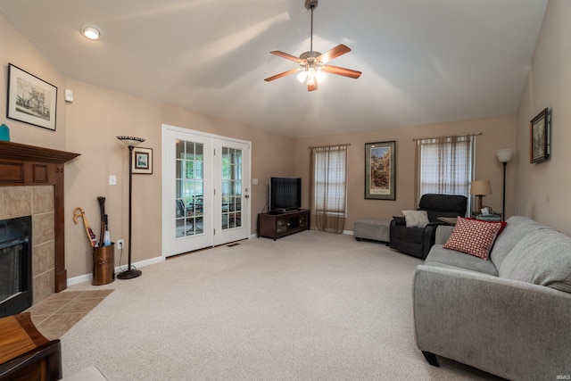 carpeted living room with ceiling fan, a tile fireplace, and plenty of natural light