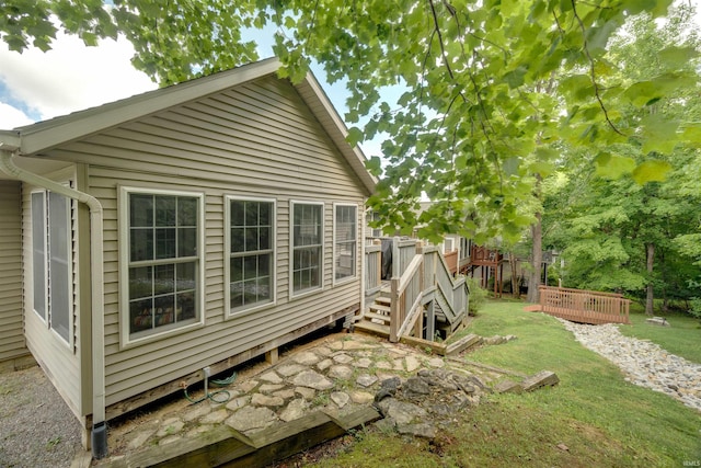 view of side of home featuring a yard and a deck