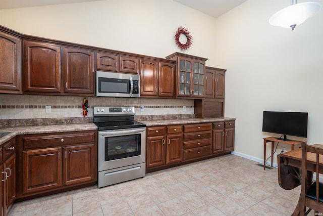 kitchen with light tile patterned floors, lofted ceiling, backsplash, and stainless steel appliances