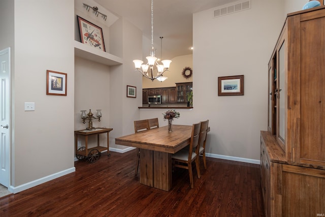 dining area with an inviting chandelier and dark hardwood / wood-style flooring