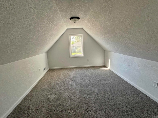 bonus room with carpet floors, a textured ceiling, and vaulted ceiling