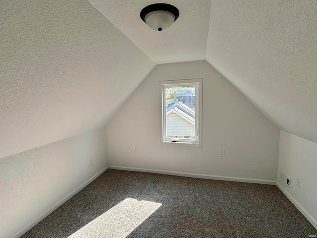 bonus room with carpet flooring, lofted ceiling, and a textured ceiling