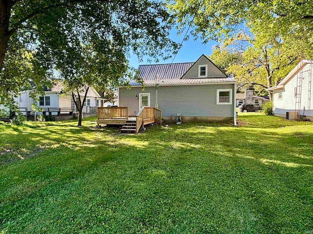 back of house featuring central AC, a wooden deck, and a yard