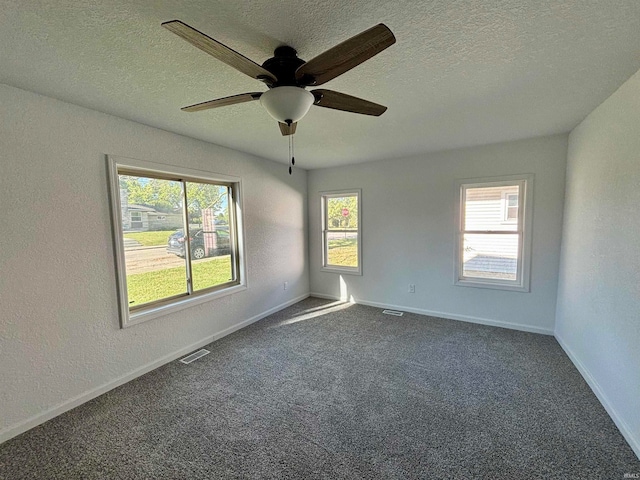 carpeted spare room with ceiling fan and a textured ceiling