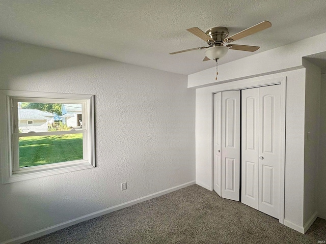 unfurnished bedroom with carpet, a textured ceiling, ceiling fan, and a closet