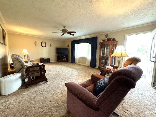 living room with ceiling fan, light colored carpet, crown molding, and a textured ceiling