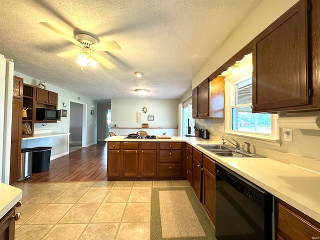 kitchen with a textured ceiling, black appliances, kitchen peninsula, sink, and ceiling fan