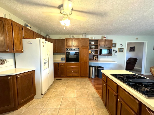 kitchen featuring black appliances, ceiling fan, light tile patterned floors, and a textured ceiling