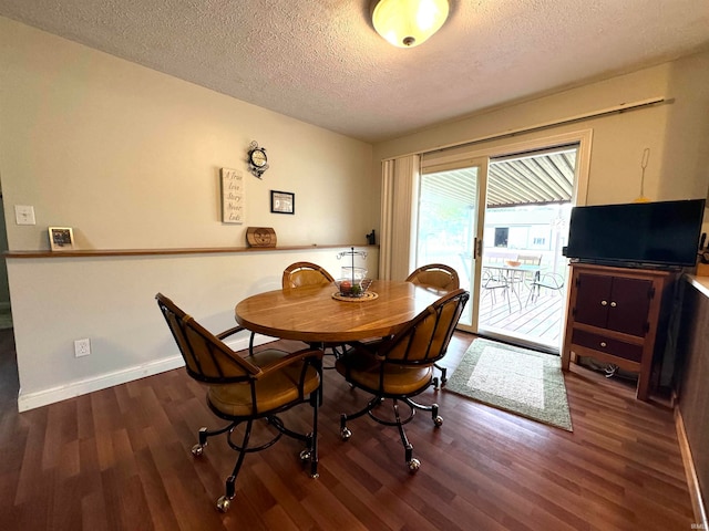 dining room with dark wood-type flooring and a textured ceiling