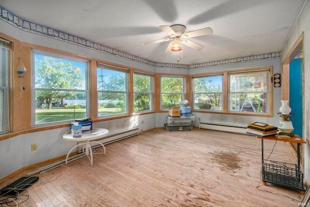 sunroom / solarium with a baseboard radiator and ceiling fan