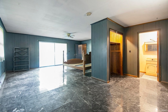 spare room with ceiling fan and wood walls