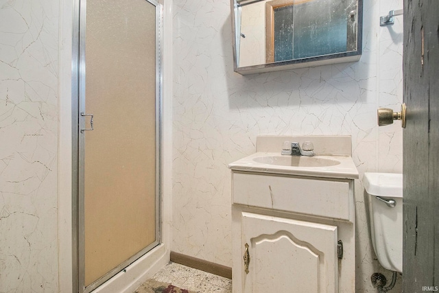 bathroom featuring vanity, toilet, and a shower with door