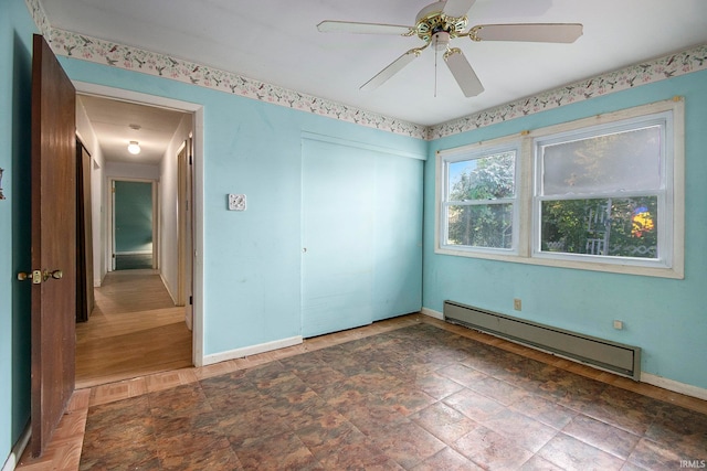 unfurnished bedroom with a closet, ceiling fan, hardwood / wood-style flooring, and baseboard heating