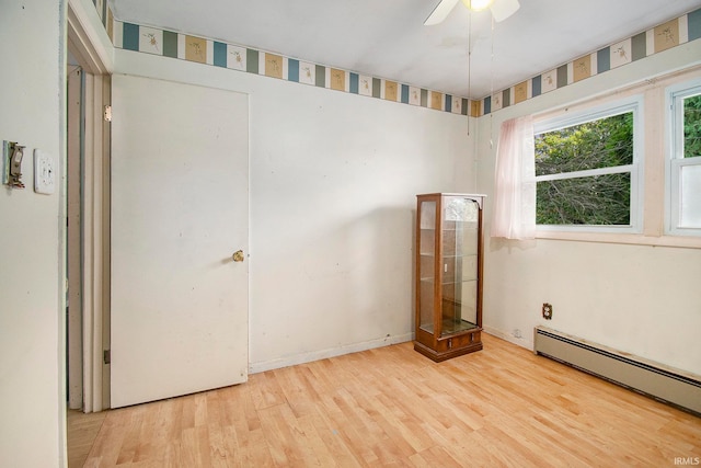 unfurnished bedroom with a baseboard heating unit, ceiling fan, and light hardwood / wood-style floors