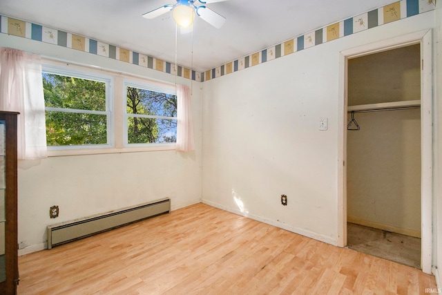 unfurnished bedroom with a closet, a baseboard radiator, light hardwood / wood-style floors, and ceiling fan