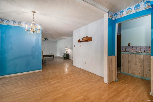 empty room with ceiling fan, a textured ceiling, and light hardwood / wood-style flooring