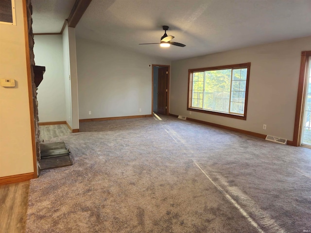 unfurnished living room featuring carpet flooring, ceiling fan, and a textured ceiling