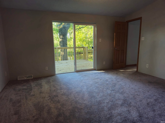 carpeted empty room with a textured ceiling