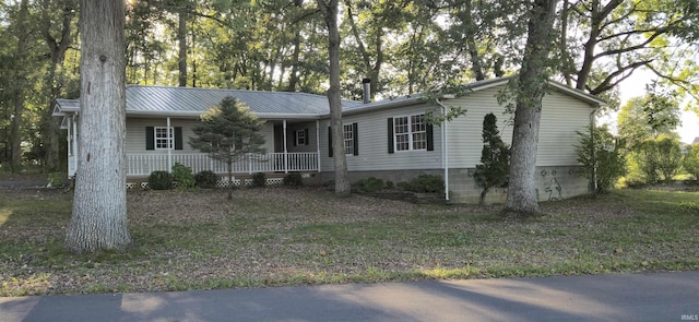 ranch-style home featuring metal roof and a porch