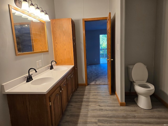 bathroom with toilet, hardwood / wood-style flooring, and vanity