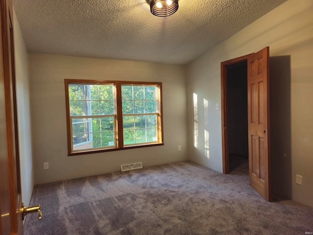 unfurnished bedroom featuring a textured ceiling and carpet flooring