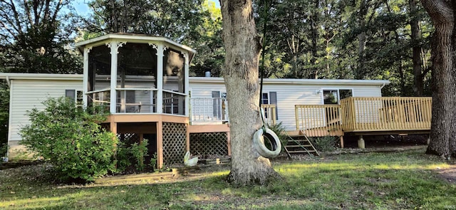 back of property with a wooden deck and a sunroom