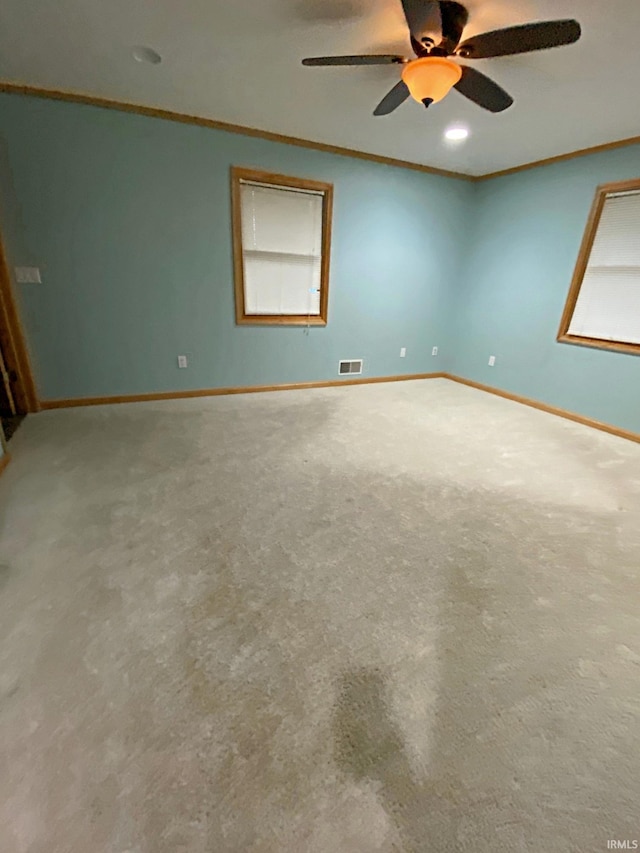 carpeted spare room featuring ceiling fan and ornamental molding