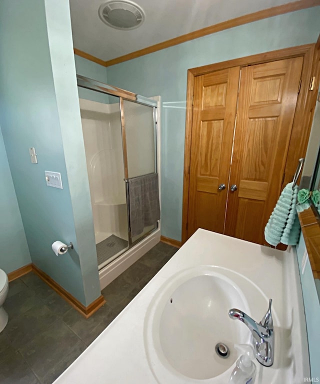 bathroom featuring toilet, an enclosed shower, tile patterned flooring, crown molding, and vanity