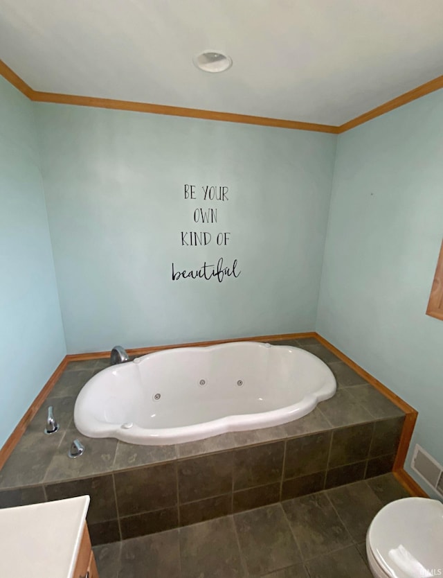 bathroom featuring crown molding, vanity, toilet, and tiled bath