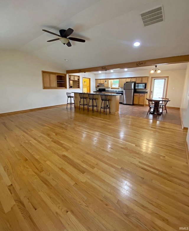 unfurnished living room featuring lofted ceiling, ceiling fan, and light hardwood / wood-style floors