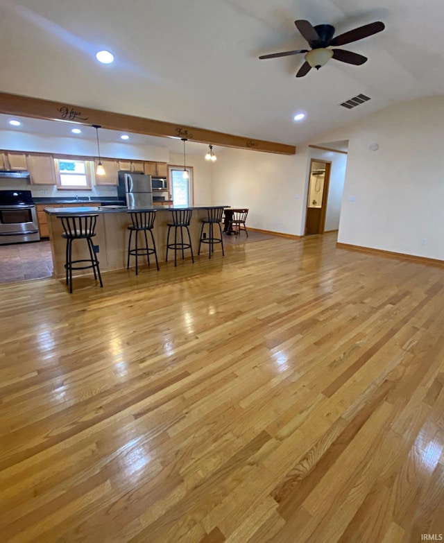 dining room featuring ceiling fan, light hardwood / wood-style floors, and vaulted ceiling