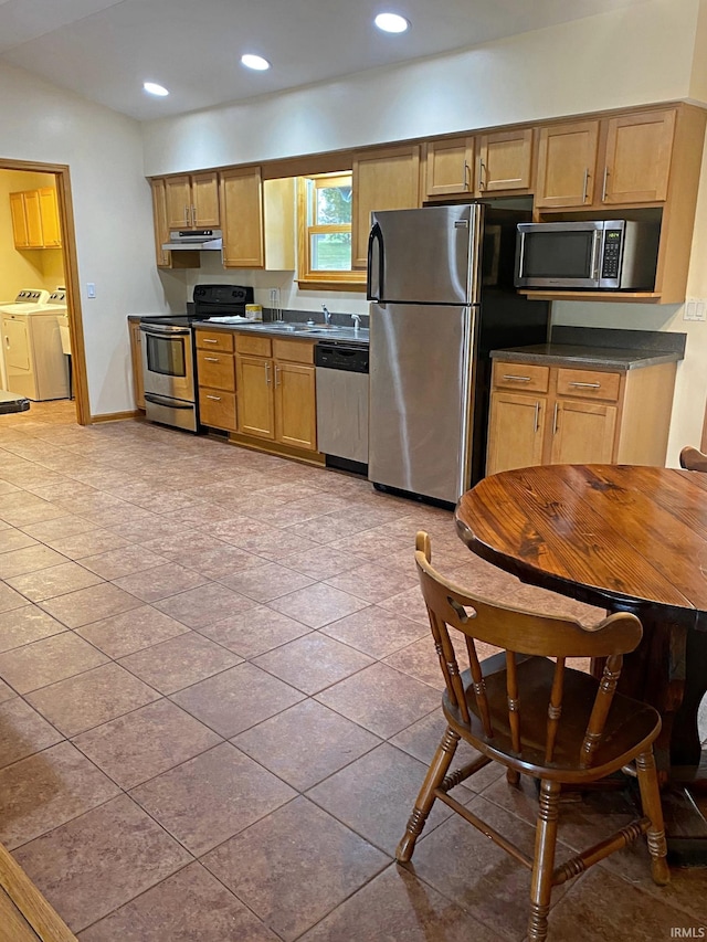 kitchen with appliances with stainless steel finishes and washing machine and dryer