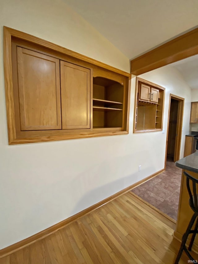 unfurnished room with hardwood / wood-style flooring and vaulted ceiling