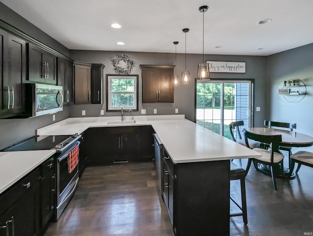 kitchen with appliances with stainless steel finishes, a kitchen bar, plenty of natural light, and sink