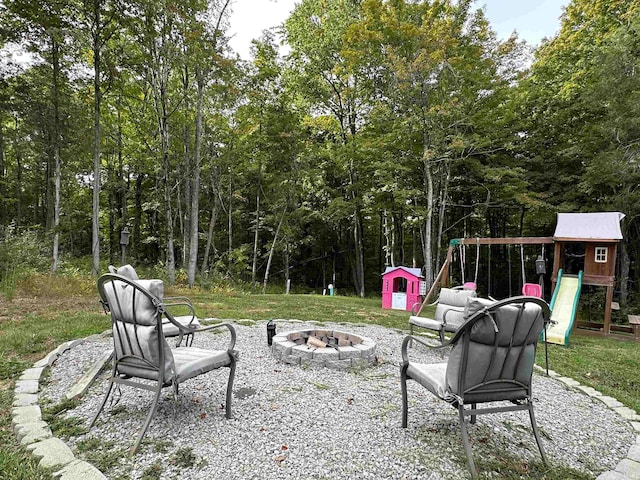 view of patio featuring an outbuilding, a fire pit, and a playground