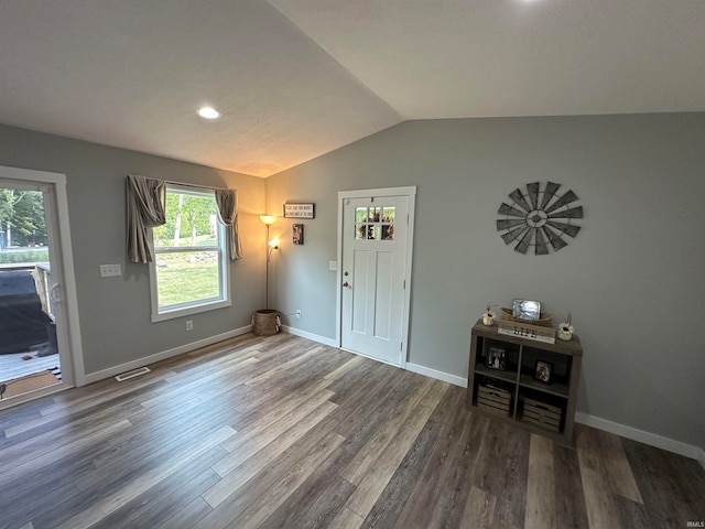 foyer entrance featuring dark wood-type flooring and vaulted ceiling