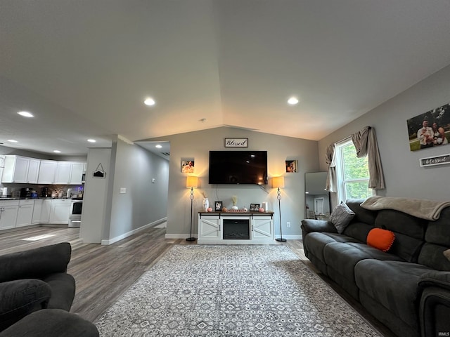 living room featuring a fireplace, lofted ceiling, and light hardwood / wood-style floors