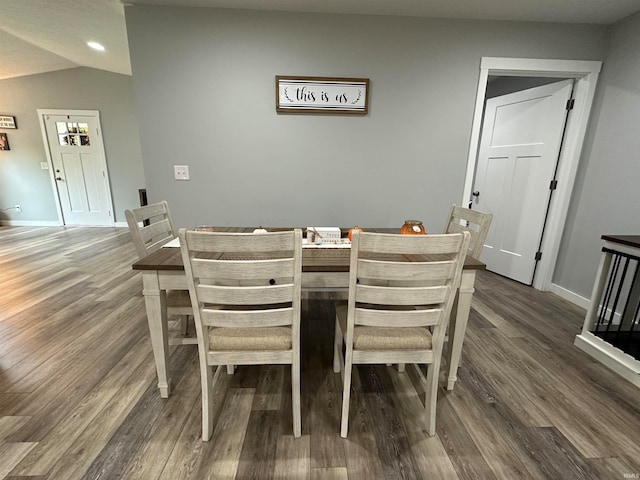 dining room featuring lofted ceiling and dark hardwood / wood-style flooring