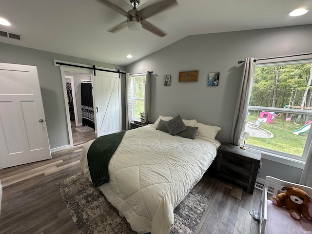 bedroom with multiple windows, lofted ceiling, ceiling fan, and a barn door