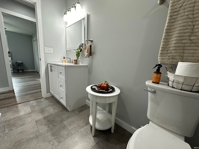 bathroom with vanity, toilet, and wood-type flooring