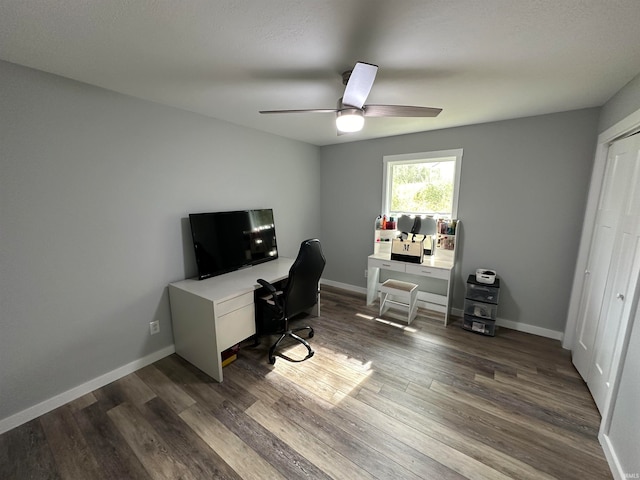 home office with dark wood-type flooring and ceiling fan