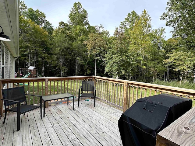 wooden terrace with area for grilling and a playground