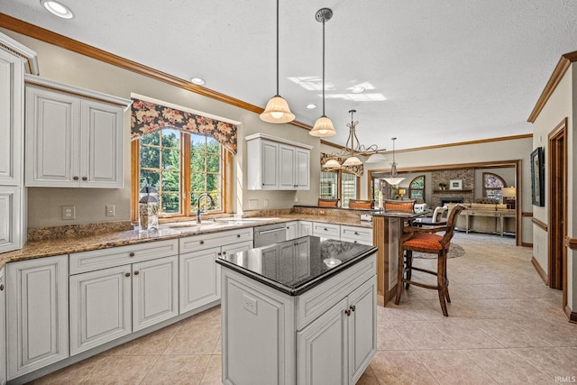 kitchen with white cabinets, light tile patterned floors, pendant lighting, ornamental molding, and a textured ceiling