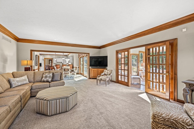 living room with a textured ceiling, carpet flooring, ornamental molding, and french doors