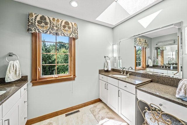 bathroom featuring a skylight and vanity