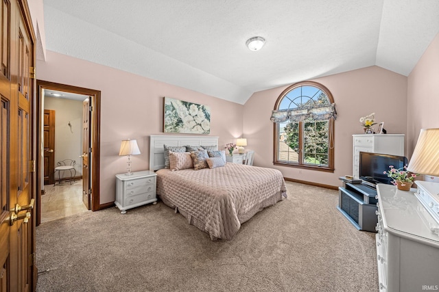 bedroom with lofted ceiling, light colored carpet, and a textured ceiling