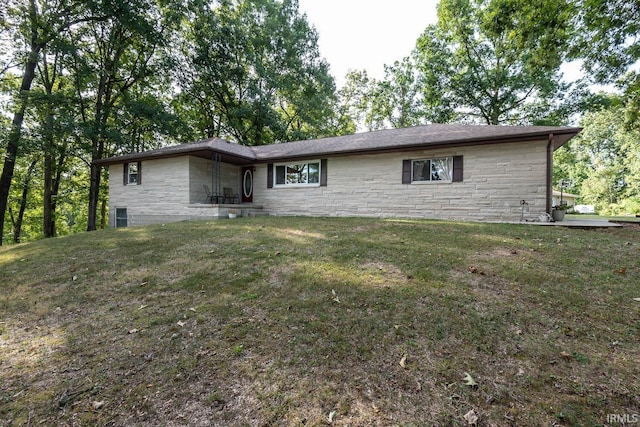 view of front facade with stone siding and a front lawn