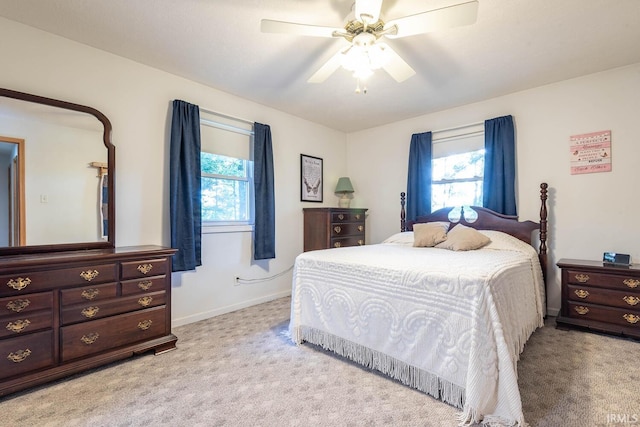 bedroom with light carpet, a ceiling fan, and baseboards